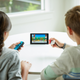 Official imagery of the new Let’s Go Pokémon game. The kid on the right is using the game’s surprisingly comfortable optional Pokéball controller.